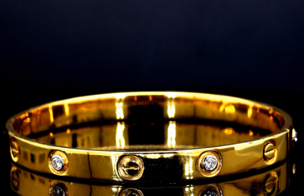 Picture of A Gold Cartier Bracelet With 6 Embedded Diamonds And The Signature Screw Motifs.